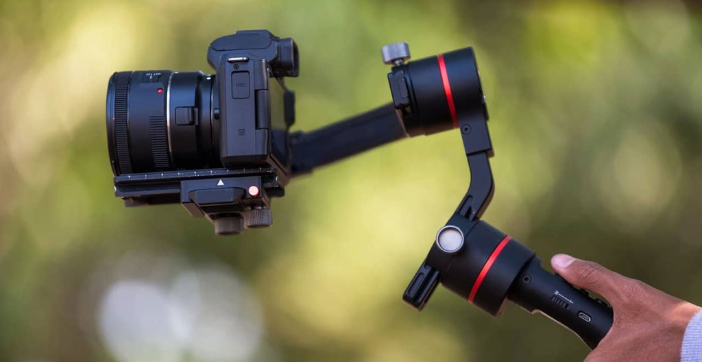 Vue en coupe d'un objectif photographique professionnel révélant le mécanisme de stabilisation optique interne avec gyroscopes et éléments optiques